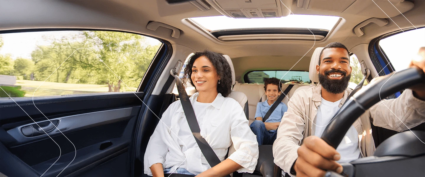 Família feliz dentro de um carro